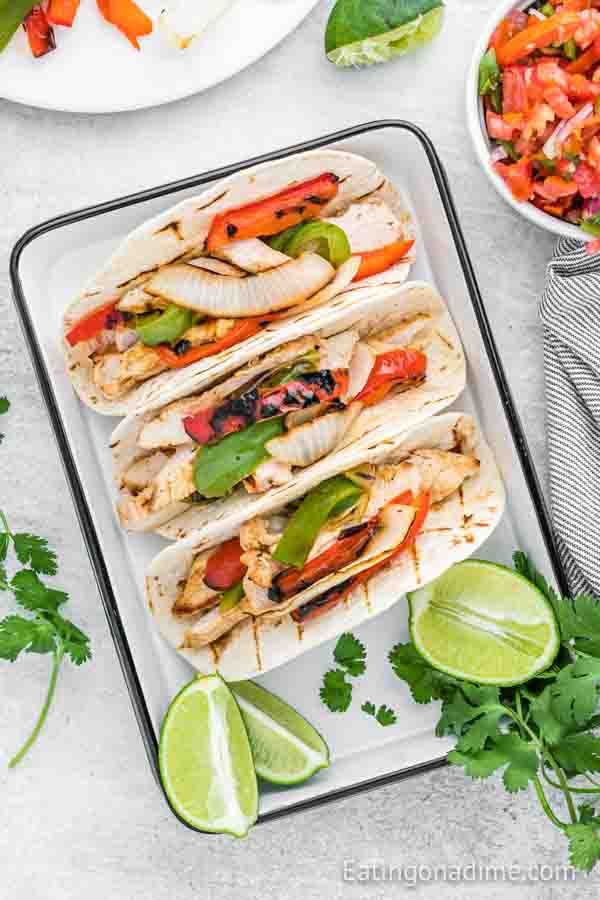 Grilled Chicken Fajitas in a baking dish with limes on the side
