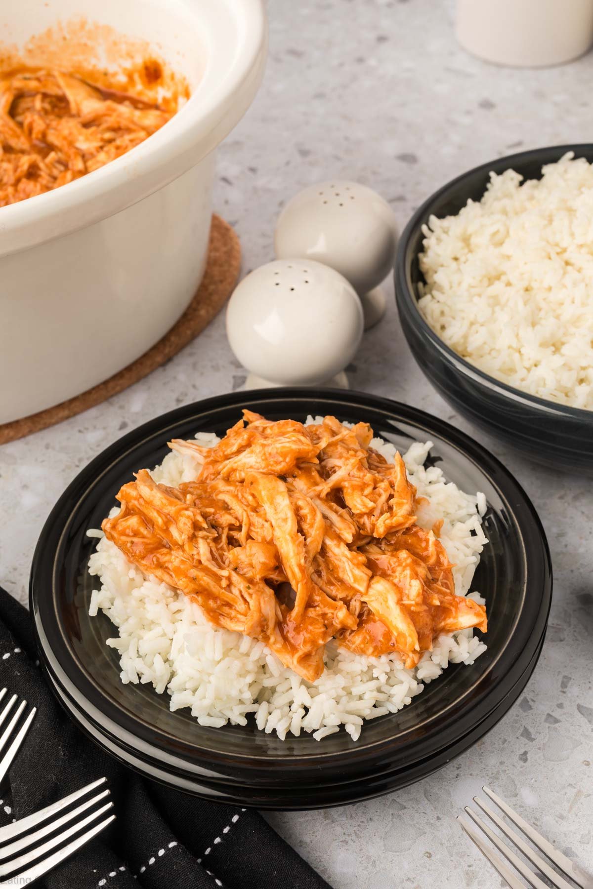 Shredded BBQ Ranch Chicken over white rice on a black plate