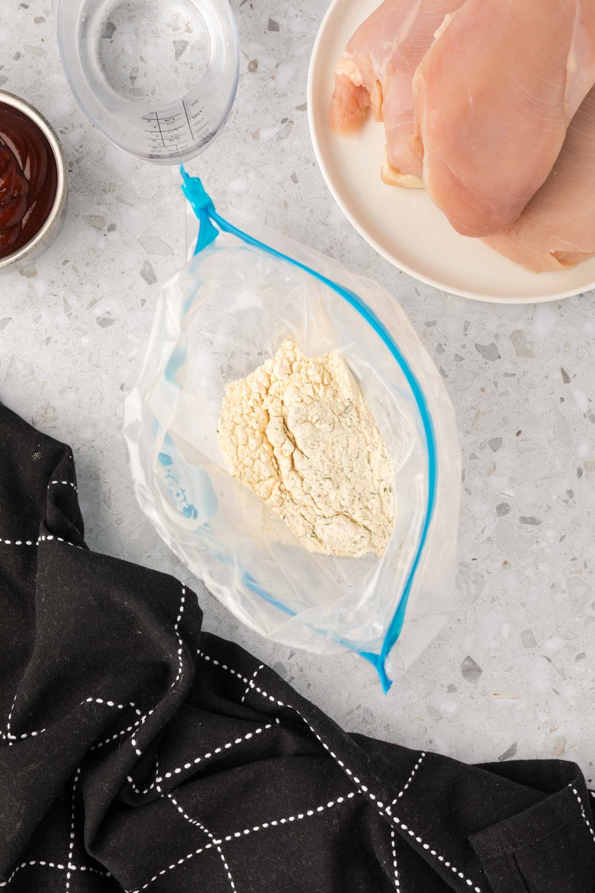 Combining the ranch seasoning mix and flour in a ziploc bag