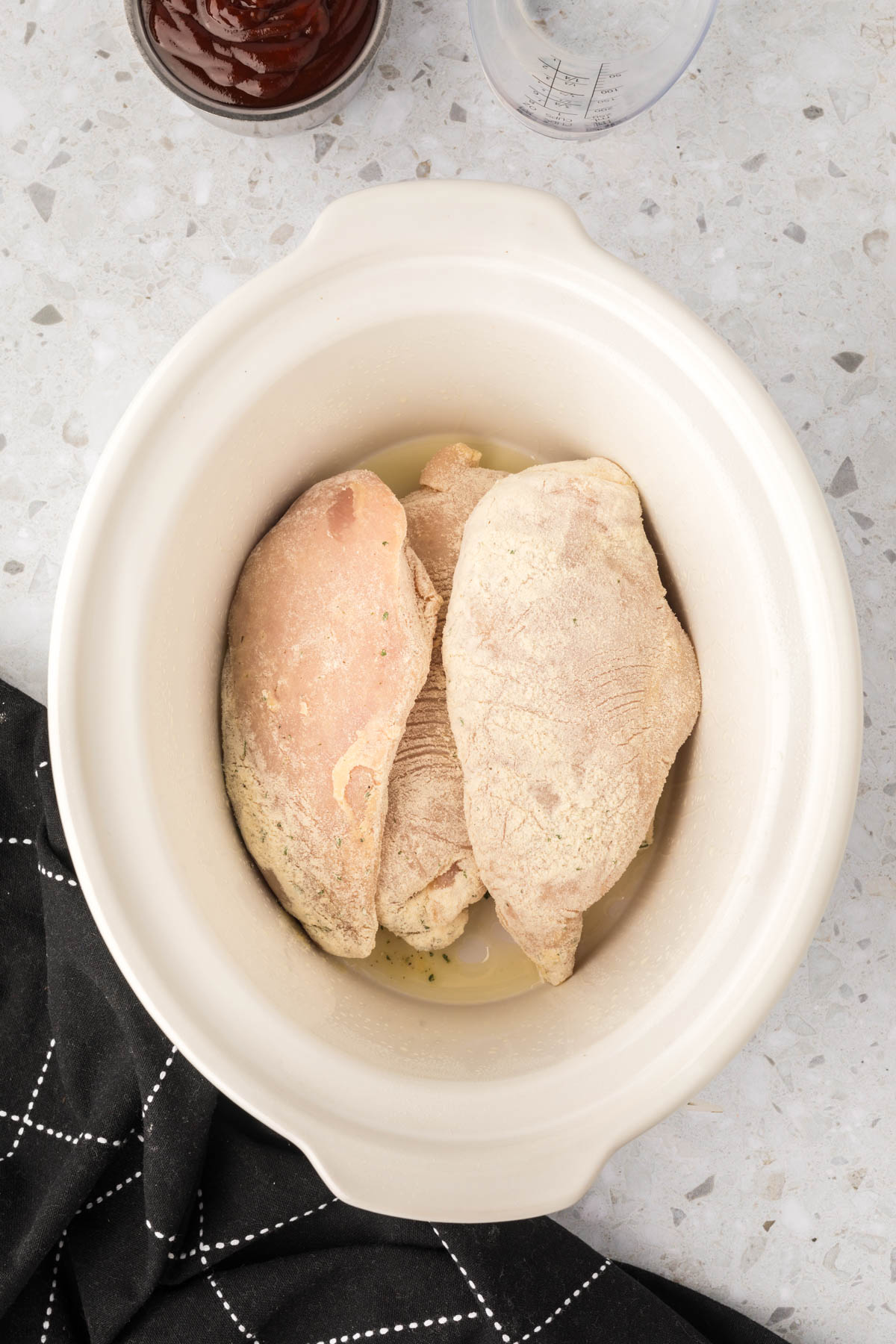 Placing seasoned chicken in the slow cooker