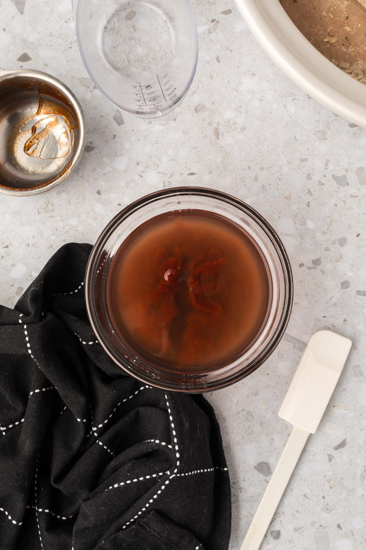 Combining BBQ sauce and water together in a bowl