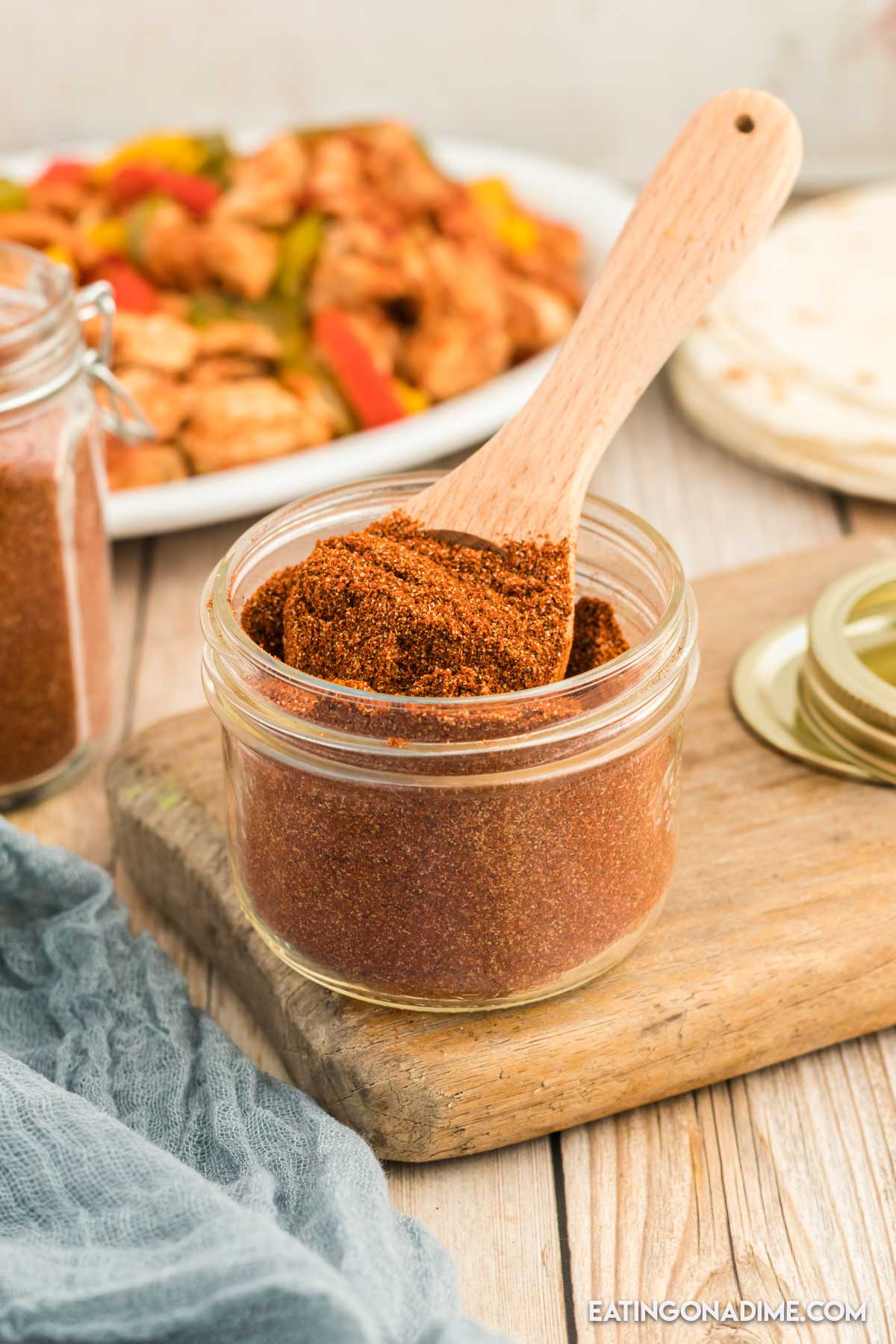 Close up image of fajita seasoning in a jar with a teaspoon