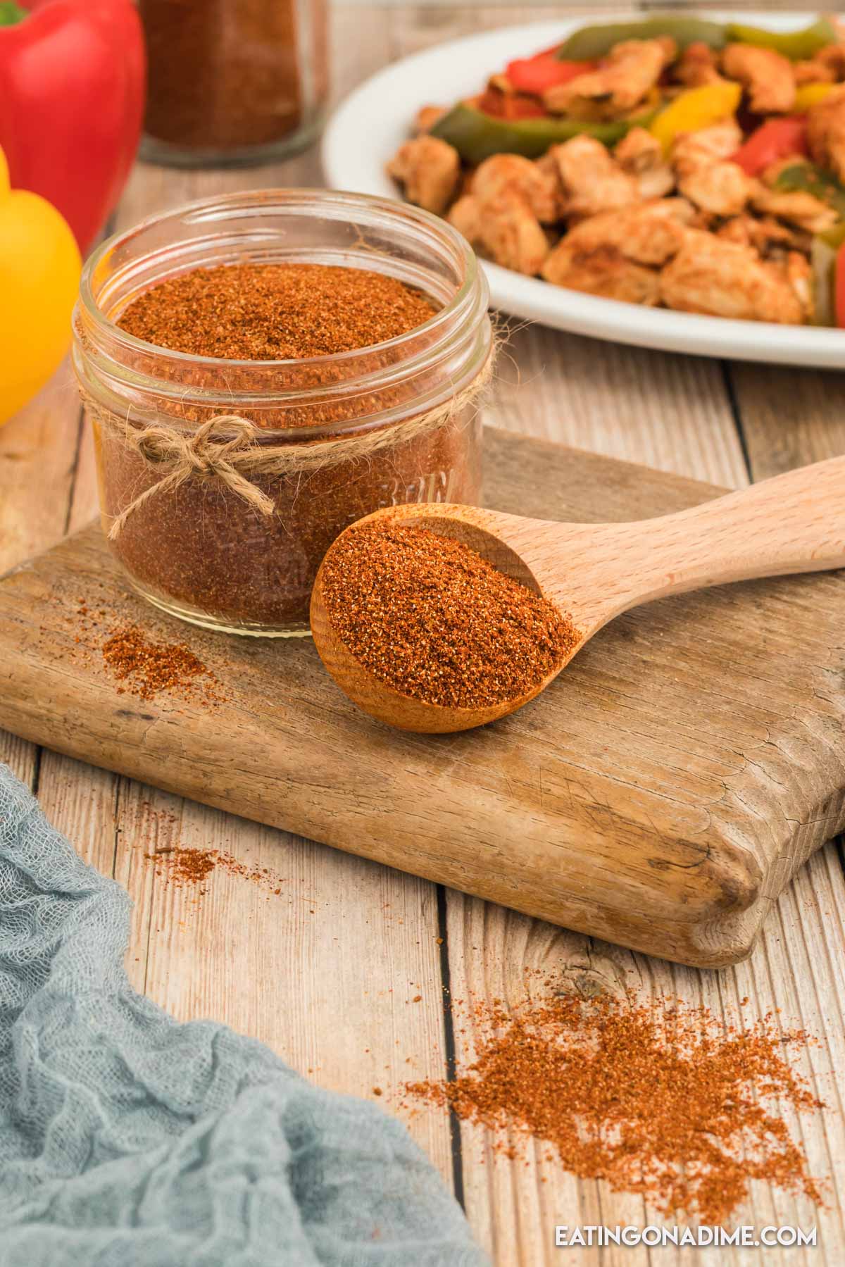 Close up image of fajita seasoning in a jar with a teaspoon