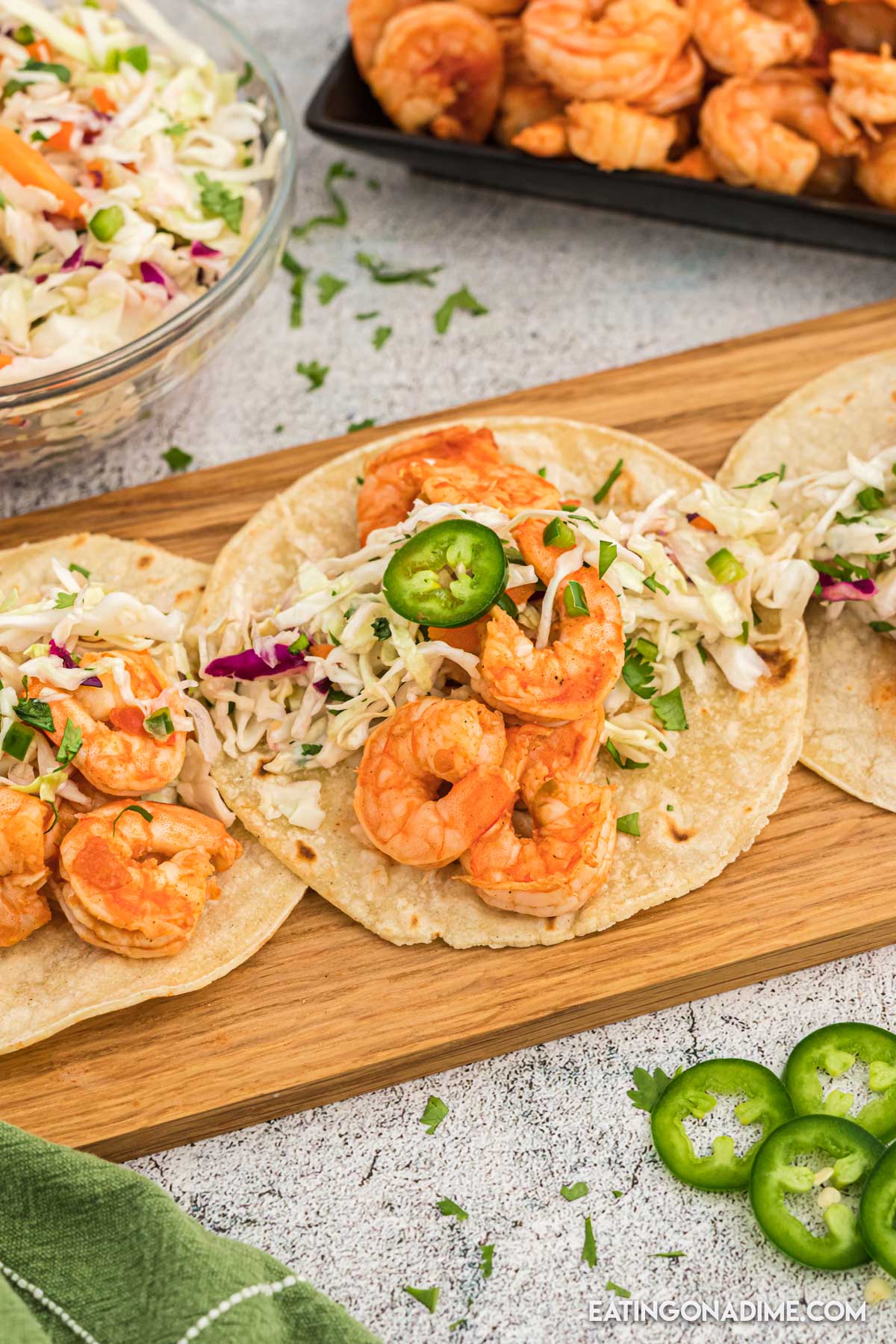shrimp tacos on a platter with a jalapenos on the side