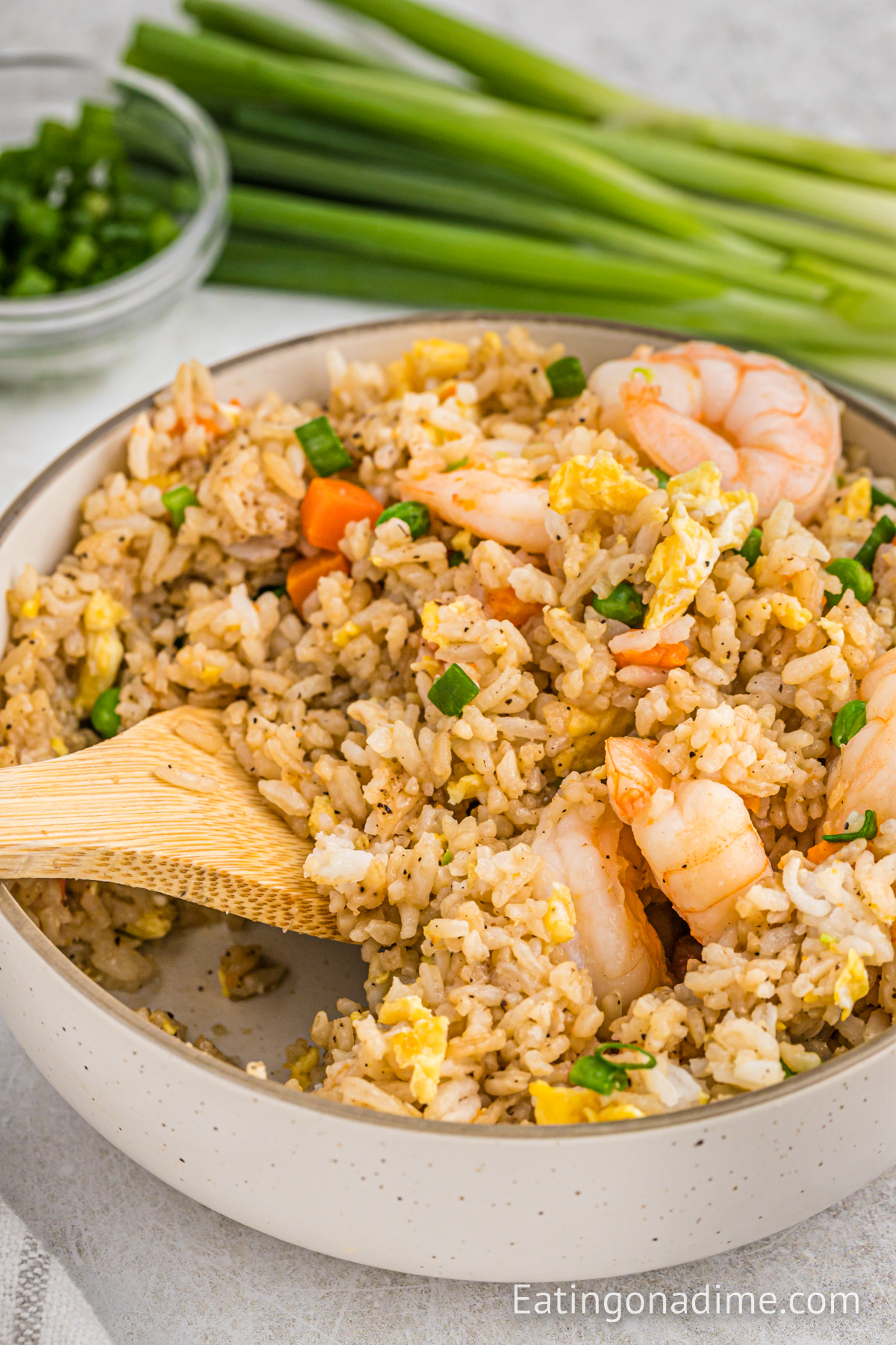 Shrimp Fried Rice in a skillet with a wooden spoon