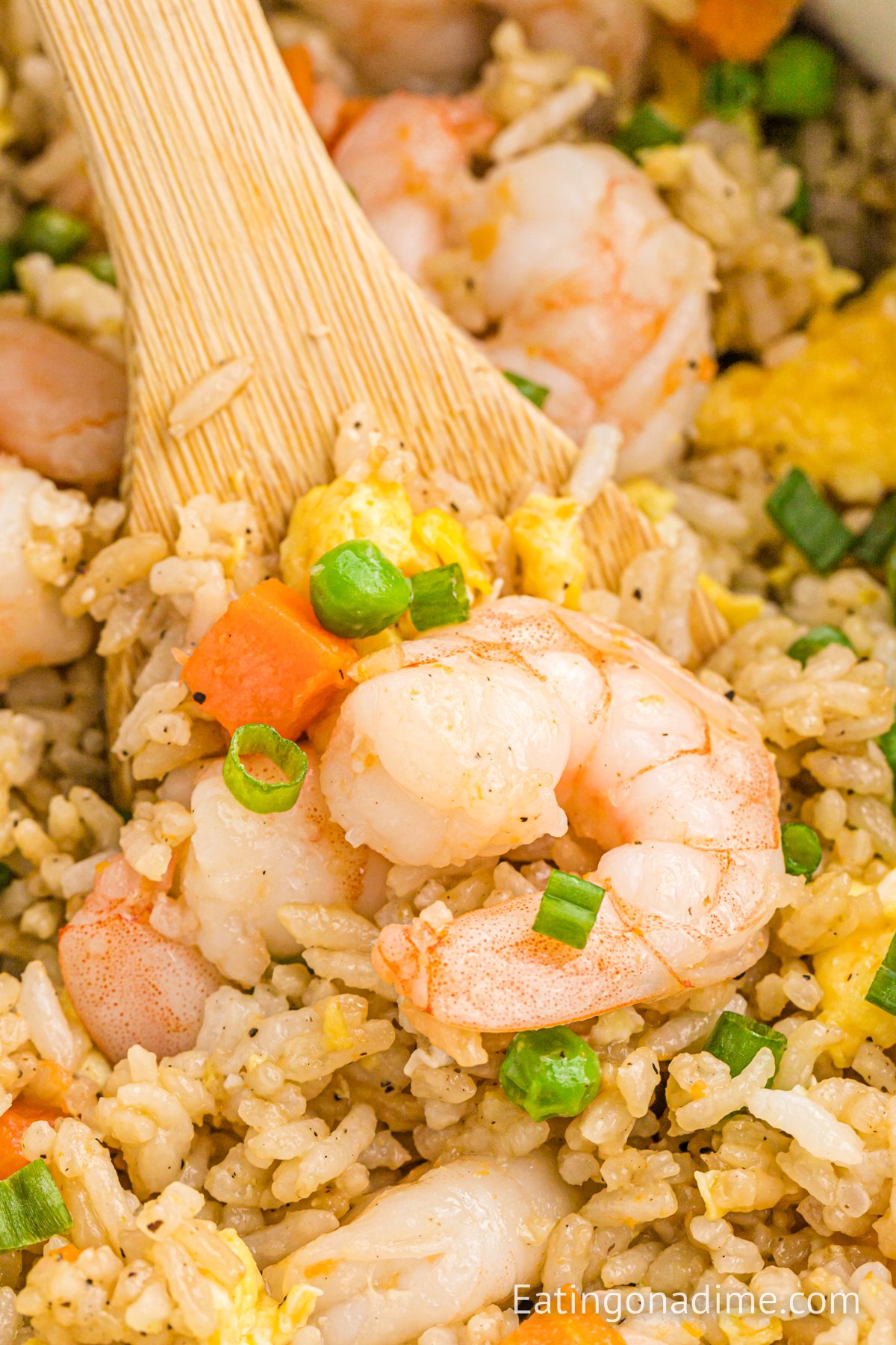 Shrimp Fried Rice in a skillet with a wooden spoon