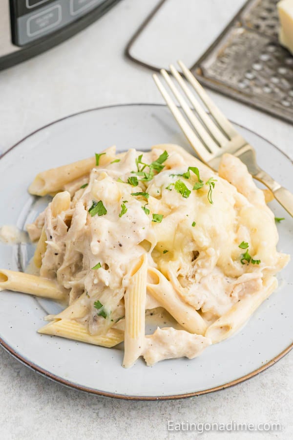 Close up image of Chicken Alfredo Casserole on a plate with a fork. 