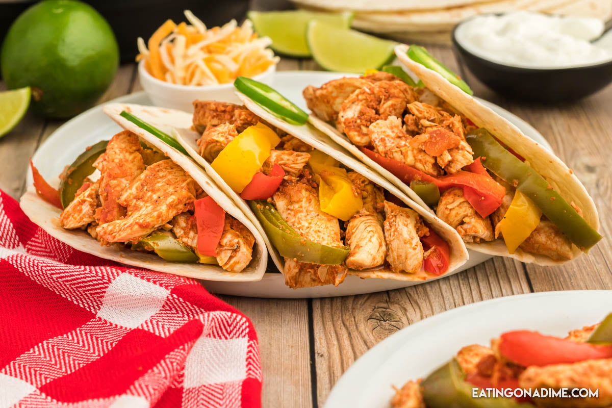 Close up image of chicken fajita with peppers on a white plate