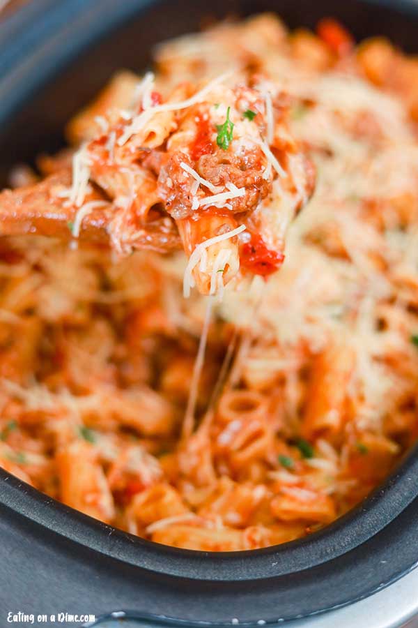 Close up image of Italian Sausage Rigatoni in a crock pot with a serving on a spoon. 