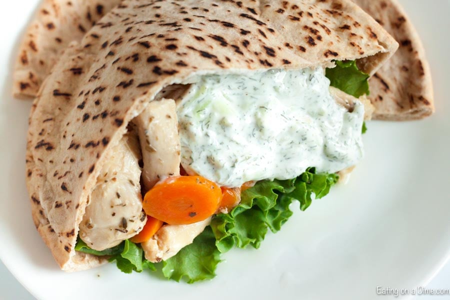 Close up image of chicken gyro with carrots and lettuce and some tzatziki sauce. 