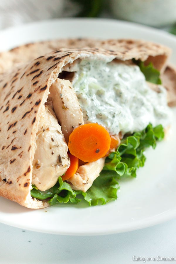 Close up image of chicken gyro with carrots and lettuce and some tzatziki sauce. 