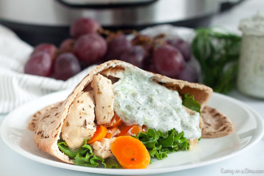 Close up image of chicken gyro with carrots and lettuce and some tzatziki sauce. 