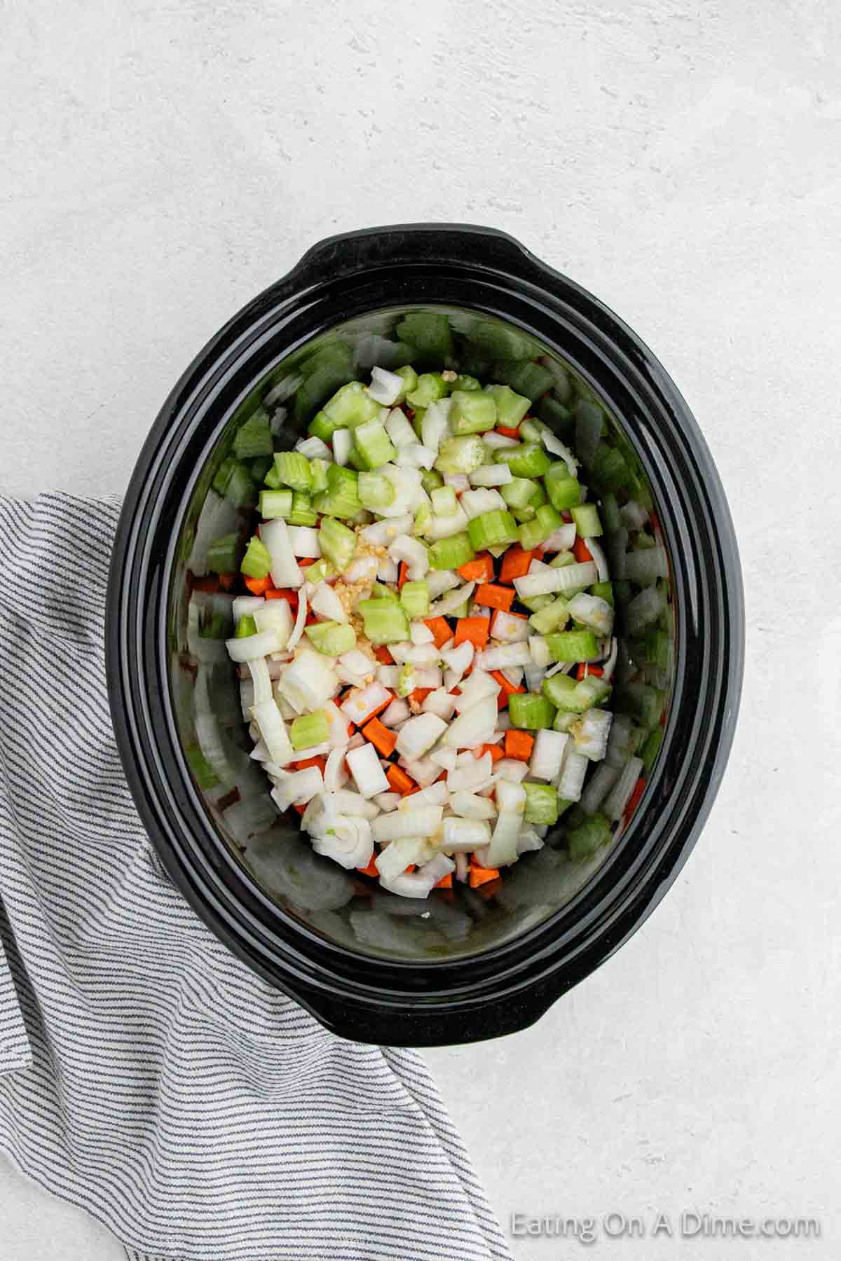 Placing the chopped veggies in the crock pot