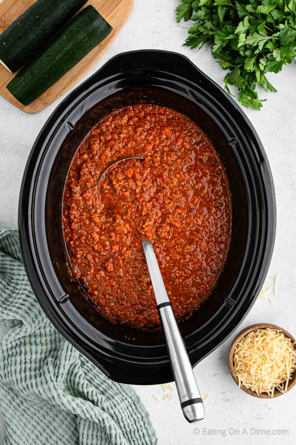 Bolognese Sauce in the slow cooker with a ladle