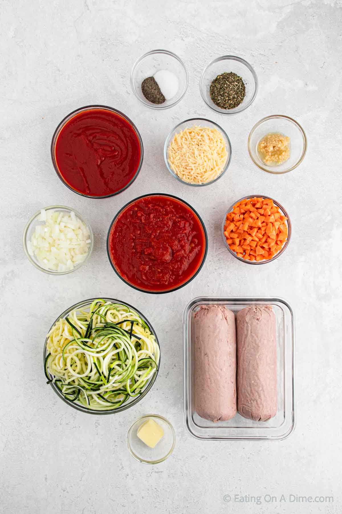 Slow Cooker Bolognese Ingredients - turkey, carrots, onion, garlic, Italian seasoning, salt and pepper, crushed tomatoes, tomato sauce, zucchini, butter, parmesan cheese