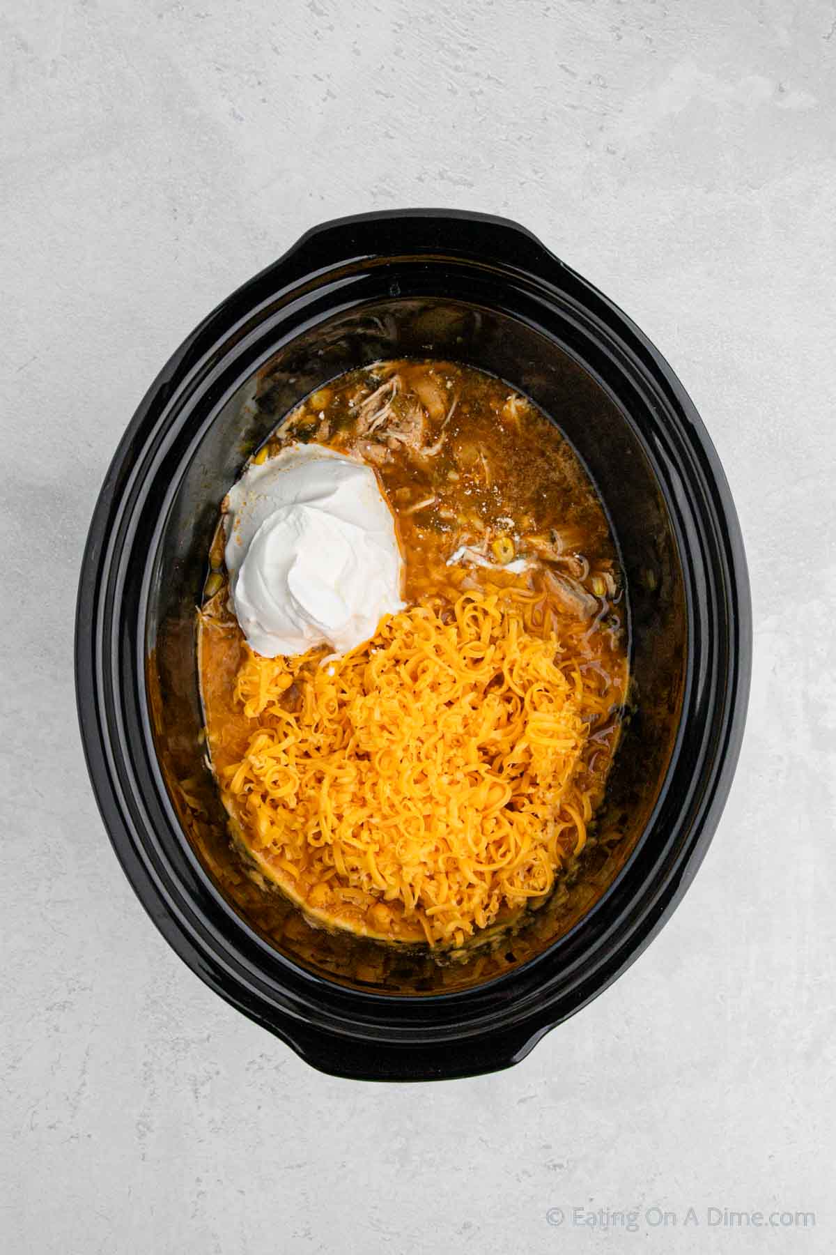 Adding the sour cream and shredded cheese in the slow cooker