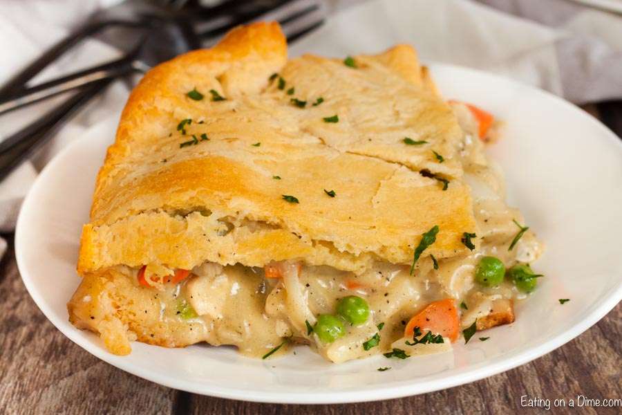 Close up image of a serving of chicken pot pie casserole on a white plate. 