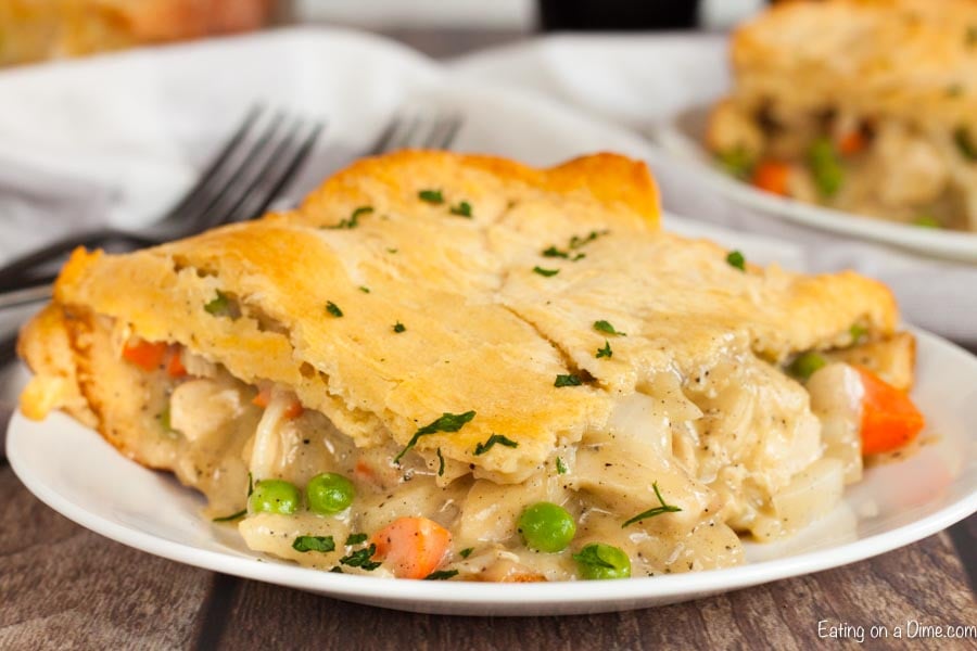 Close up image of a serving of chicken pot pie casserole on a white plate. 