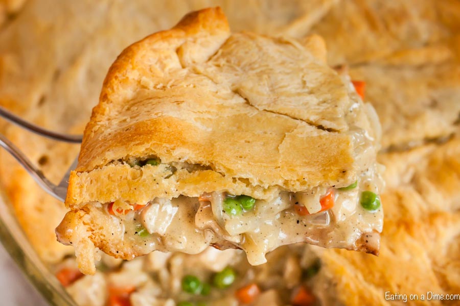 Close up image of chicken pot pie being dished out of the baking dish. 