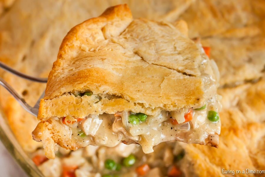 Close up image of chicken pot pie being dished out of the baking dish. 