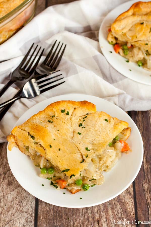 Close up image of chicken pot pie on a white plate with 3 forks. 