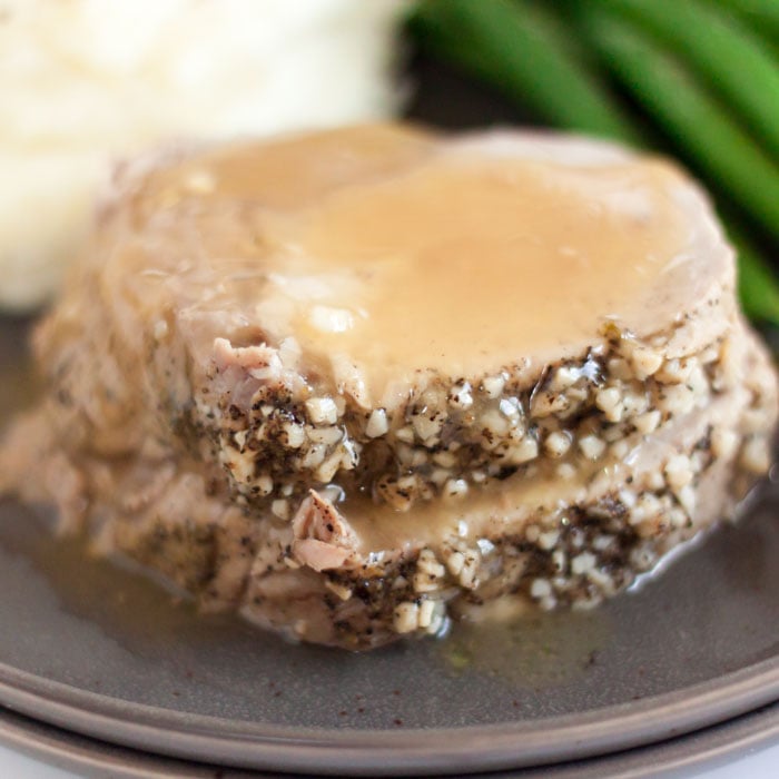 Crock Pot Pork Loin Recipe is so tender and flavorful. Top each slice of boneless crock pot pork loin roast with gravy for the best comfort food. Crock pot pork loin slow cooker is easy and delicious. #eatingonadime #crockpotporkloinroastrecipe #recipeseasy