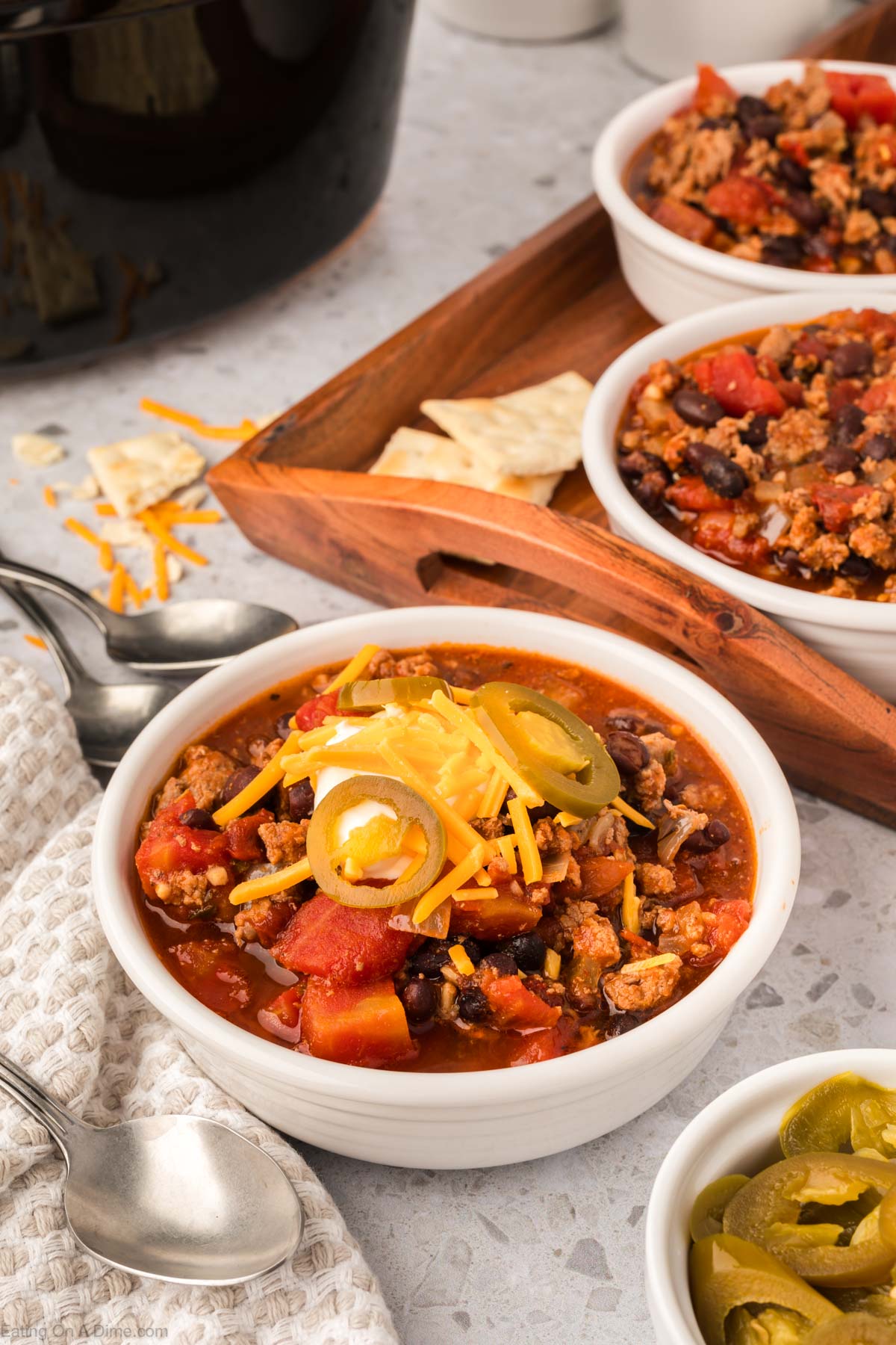 Chipotle Chili in a white bowl topped with shredded cheese, jalapenos
