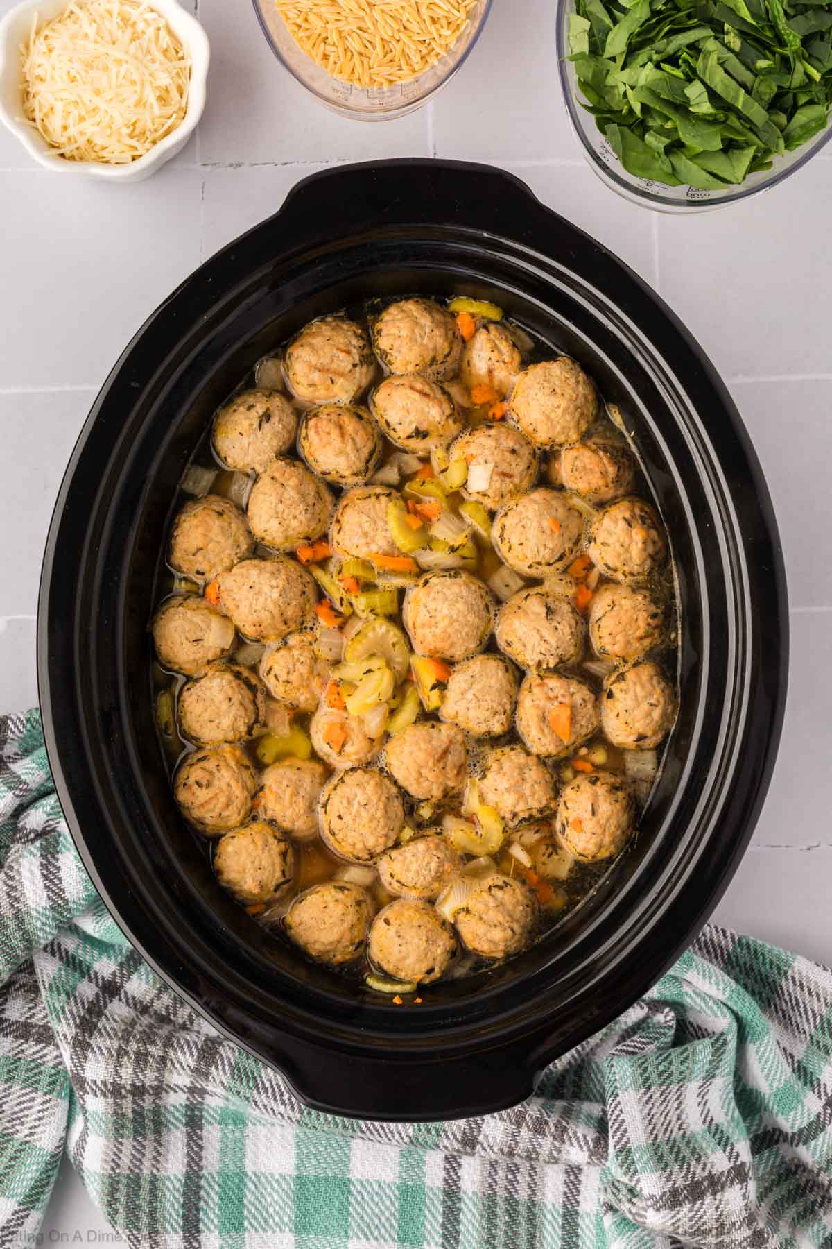 Cooking the meatball with the broth and veggies in the slow cooker