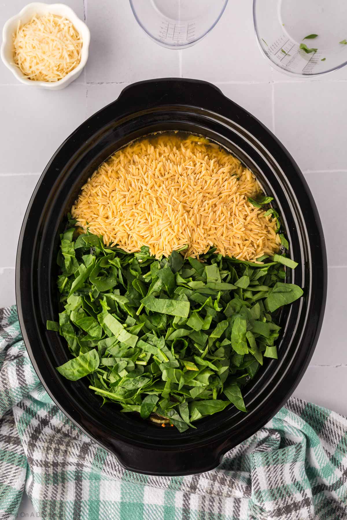 Adding the spinach and Orzo to the slow cooker