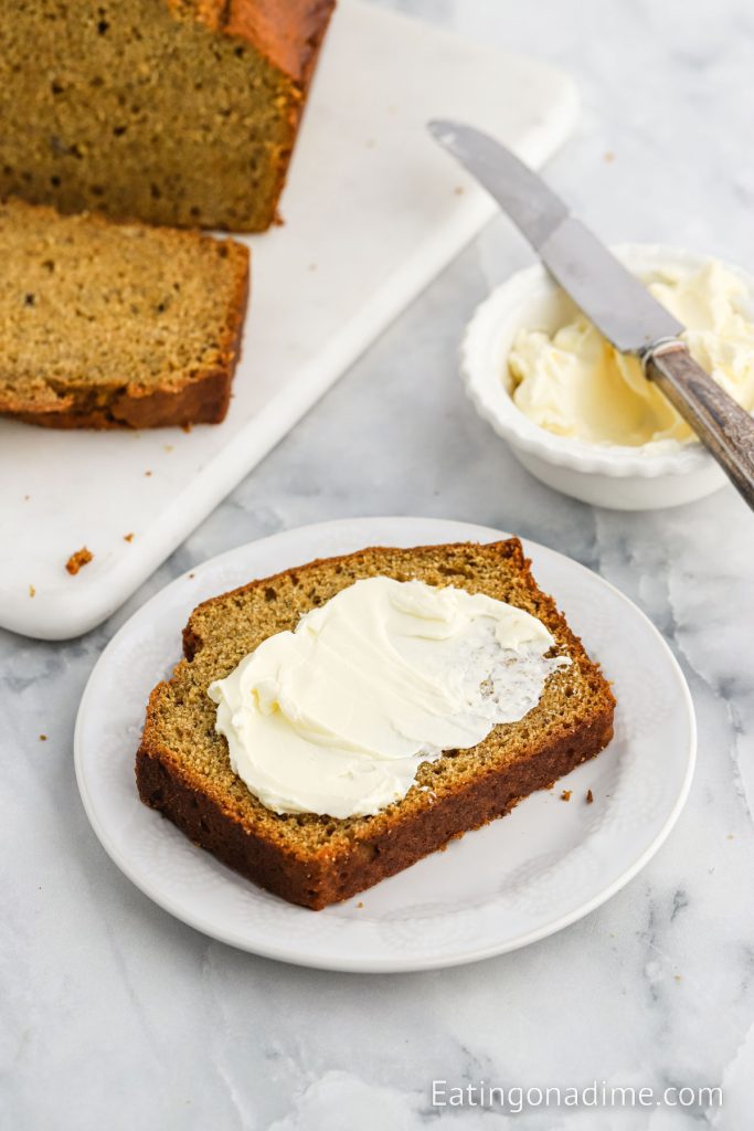 Slice of pumpkin banana bread on a plate with butter