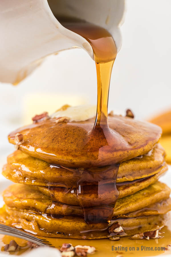 Close up image of pumpkin pancakes stacked with syrup.