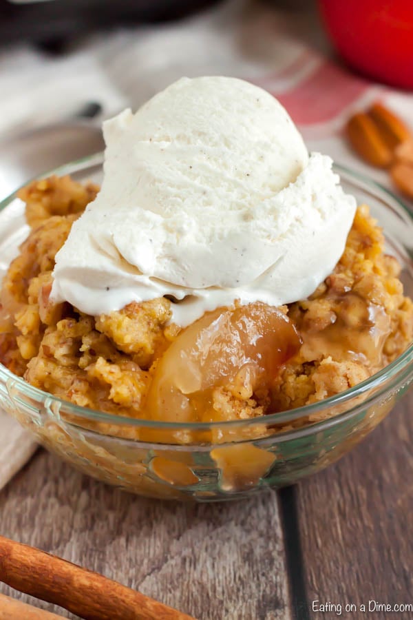Apple dump cake with vanilla ice cream on top in a bowl