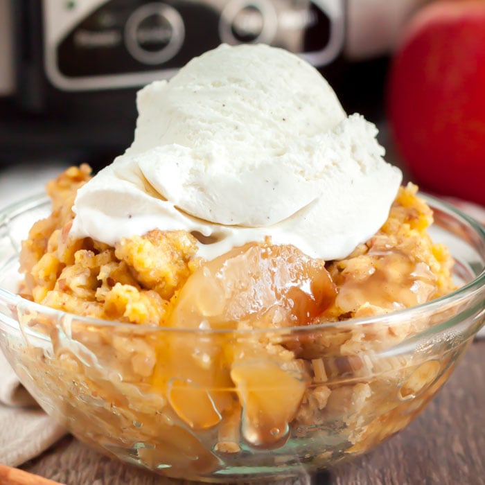Apple dump cake with vanilla ice cream on top in a bowl