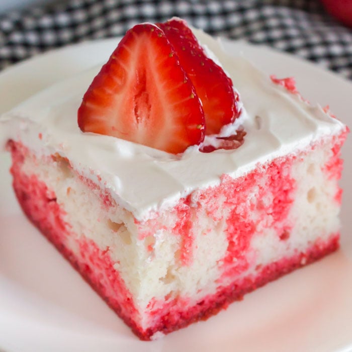 Close up image of Strawberry Jello Cake on a white plate. 