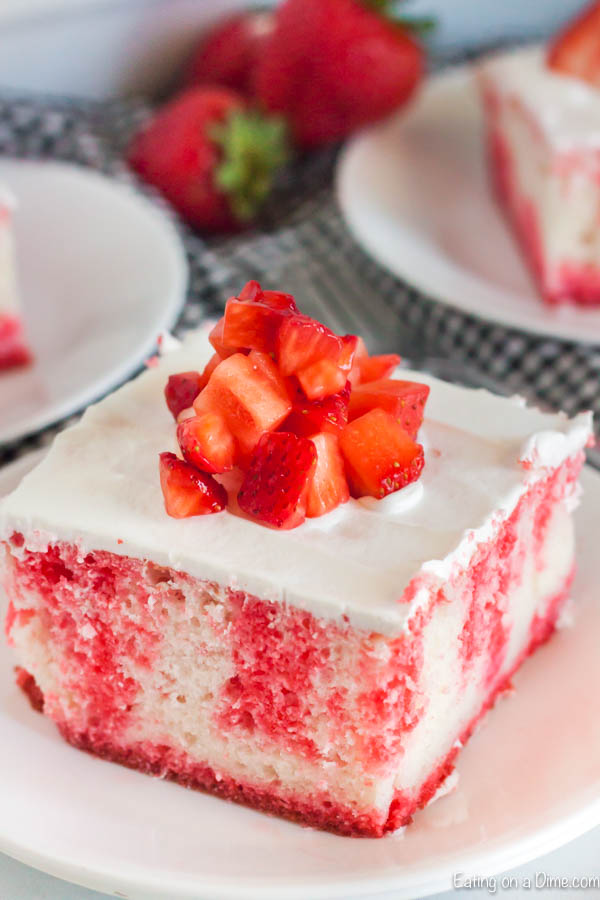 Close up image of a serving of Strawberry Jello Cake on a white plate