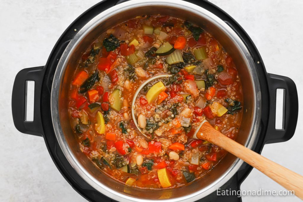 Quinoa Soup in the Instant Pot with a wooden spoon