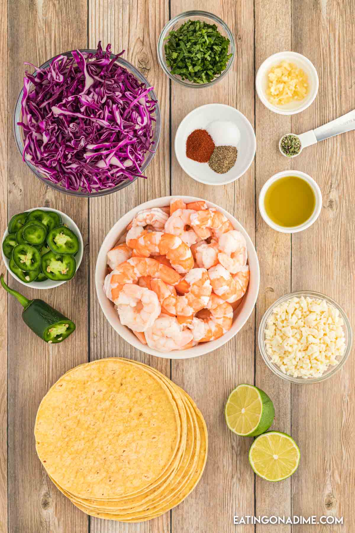 Ingredients needed - olive oil, precooked shrimp, salt and pepper, garlic, paprika, oregano, lime, corn tortilla, red cabbage, jalapeno, cilantro cojita cheese