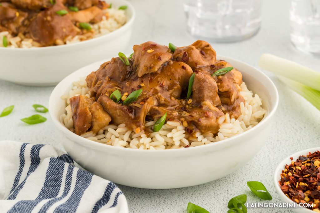 Bourbon Chicken in a bowl over rice with a fork