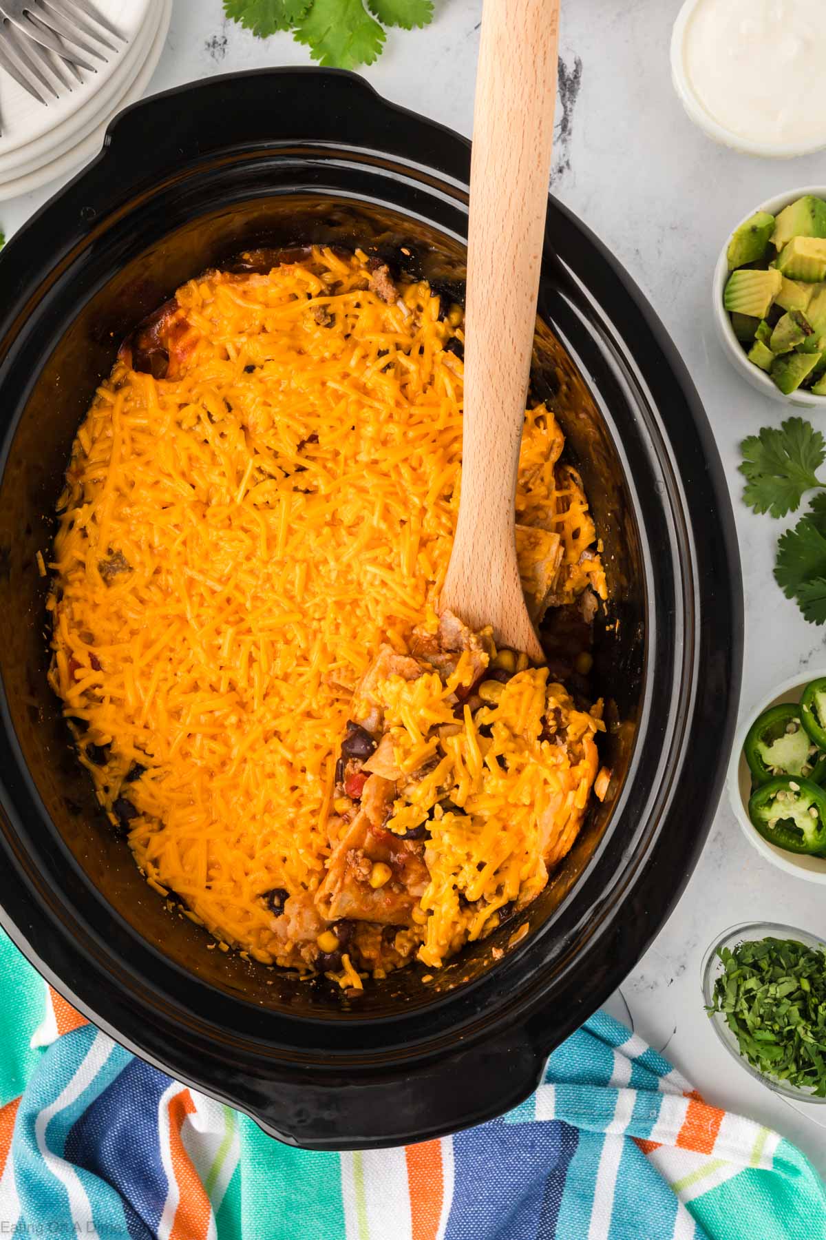 Mexican Casserole in a slow cooker with a wooden spoon