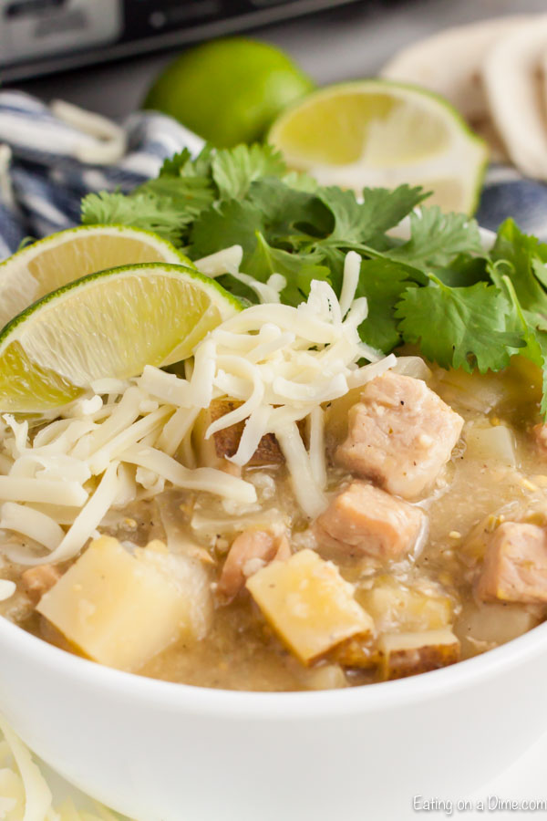 Close up image of green chili pork stew in a white bowl. 