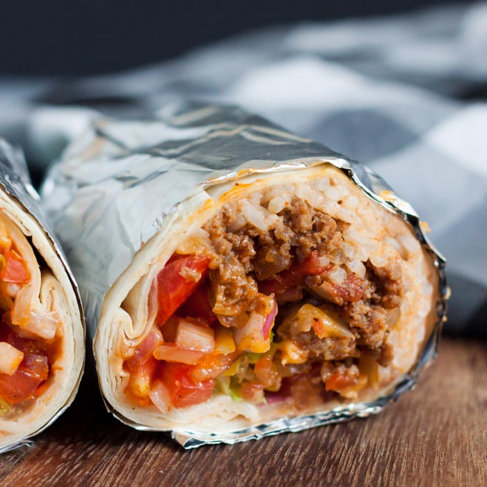closeup photo of beef burrito wrapped in foil.