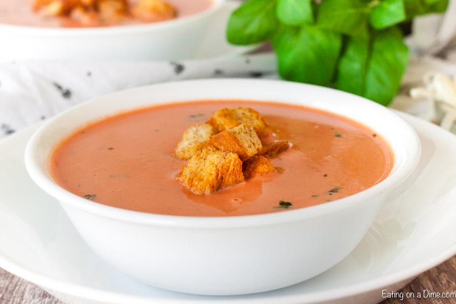 A bowl of creamy tomato soup topped with homemade croutons 