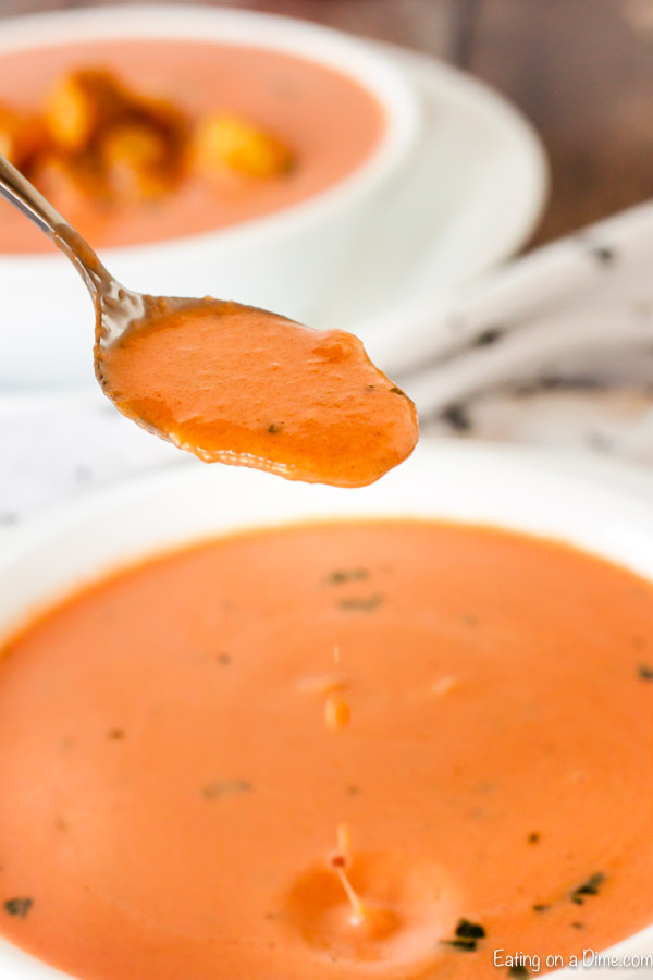 Bowl of creamy tomato soup with a spoon. 