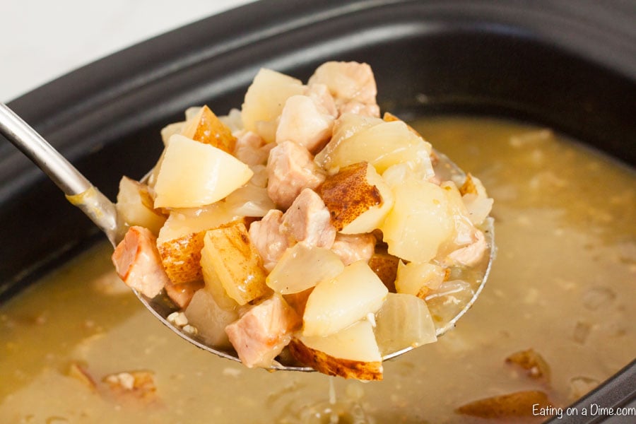 Close up image of a serving out of the crock pot of chili stew on a large spoon. 