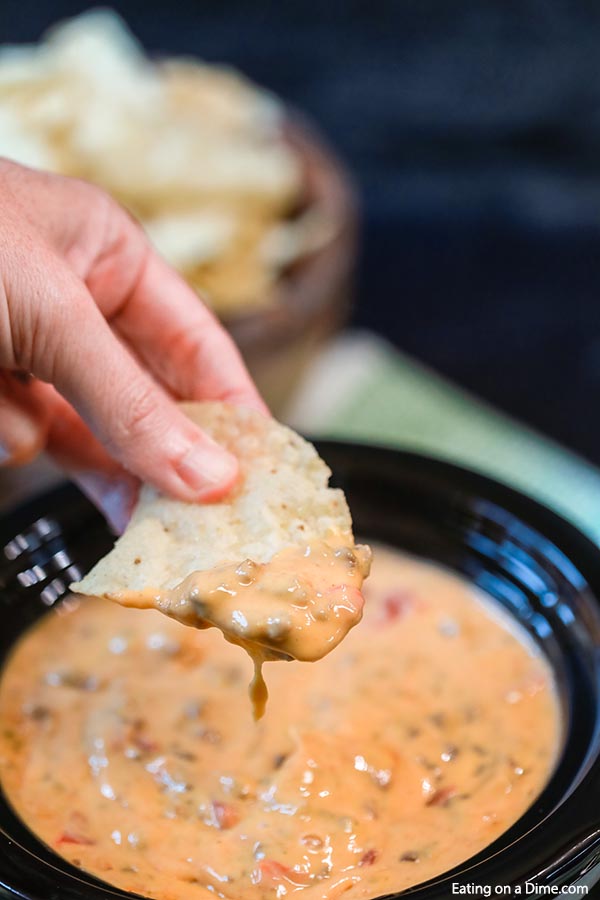 Rotel Dip in the slow cooker with a a bite on a chip