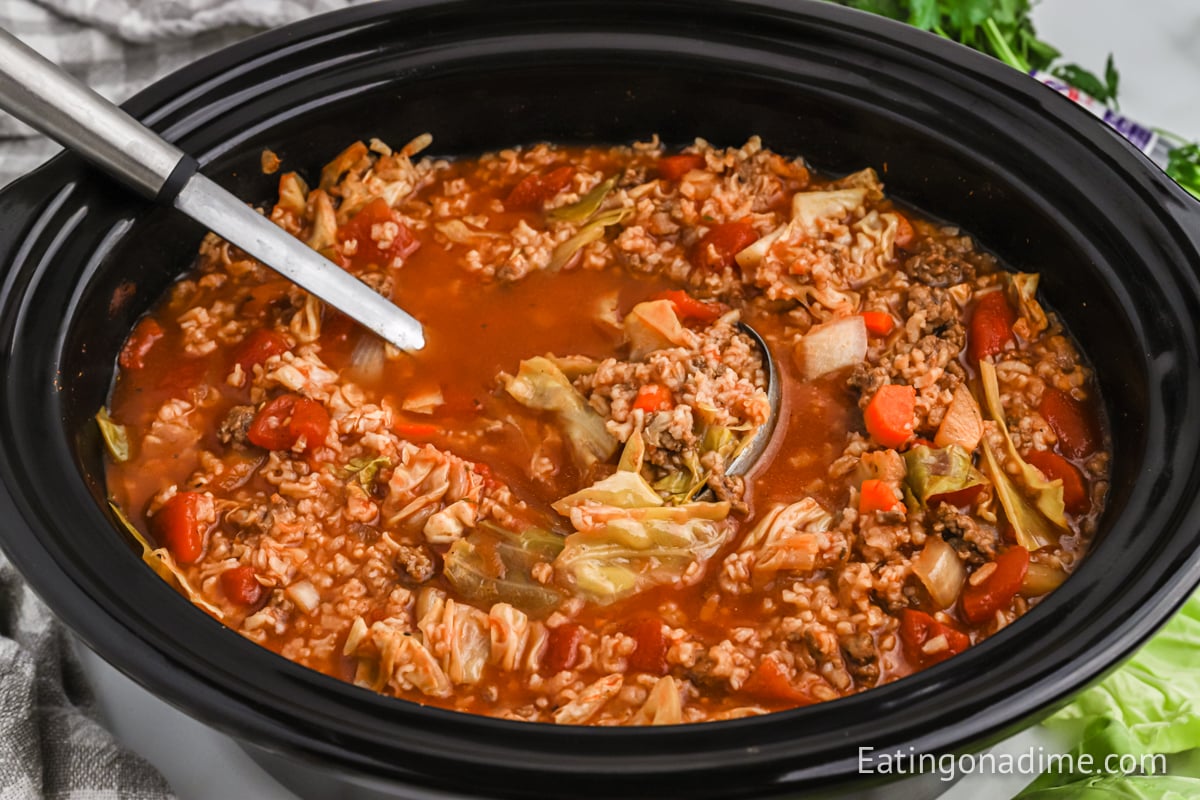 cabbage soup in the slow cooker with a ladle