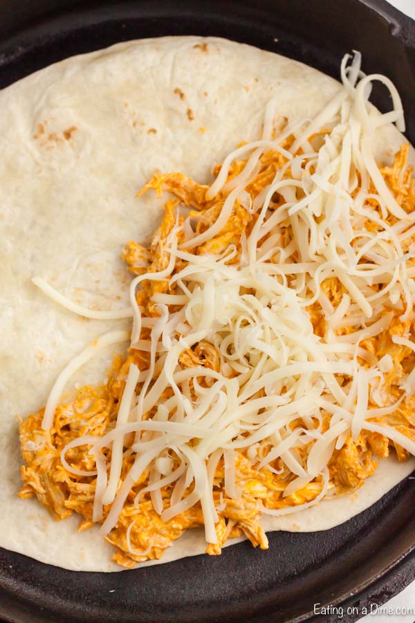 Adding the cheese to the chicken in a tortilla