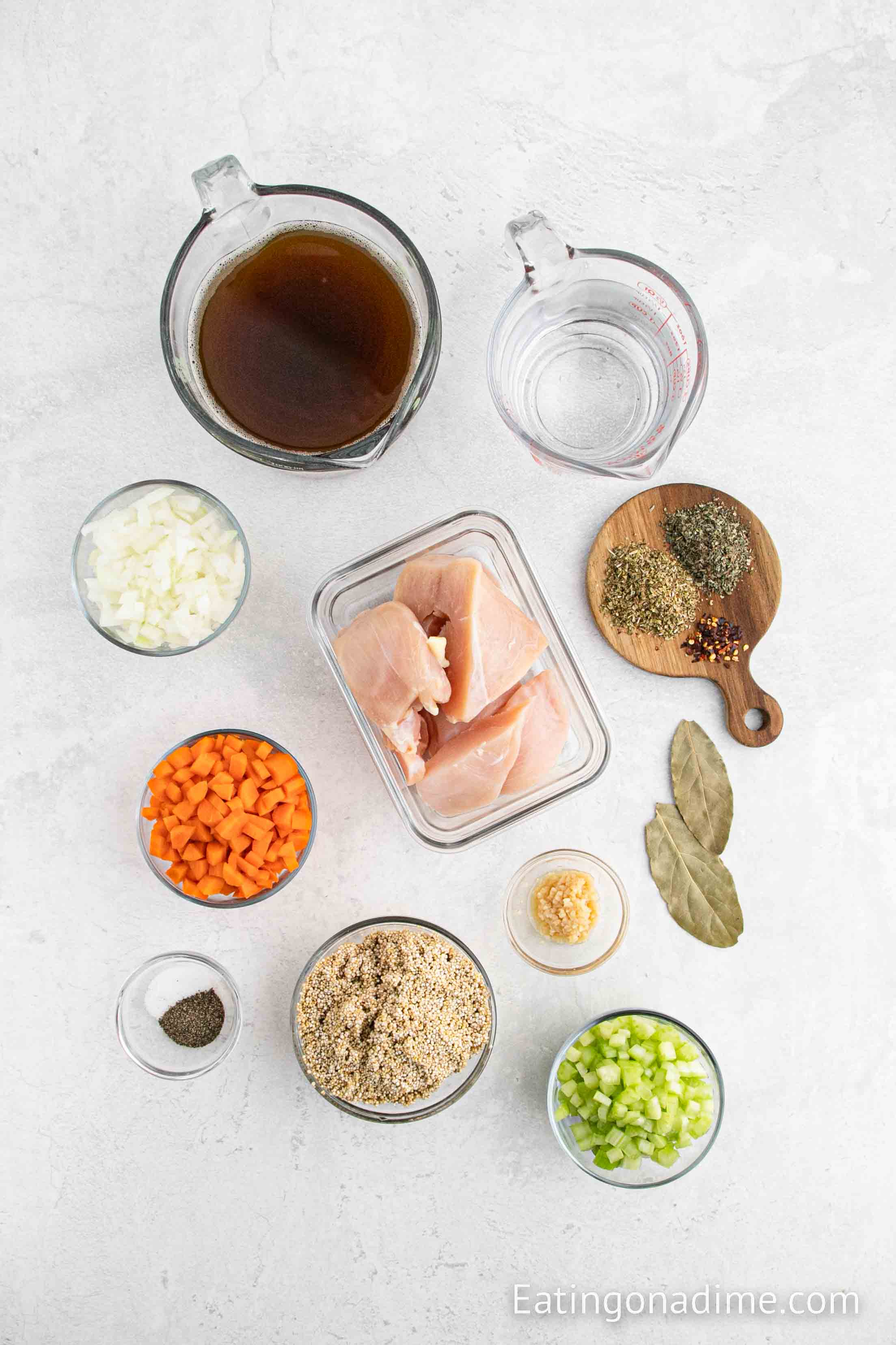 ingredients for chicken quinoa soup - chicken, quinoa, carrots, celery, onion, chicken broth, garlic, bay leaves, oregano, basil, red pepper flakes, salt, pepper