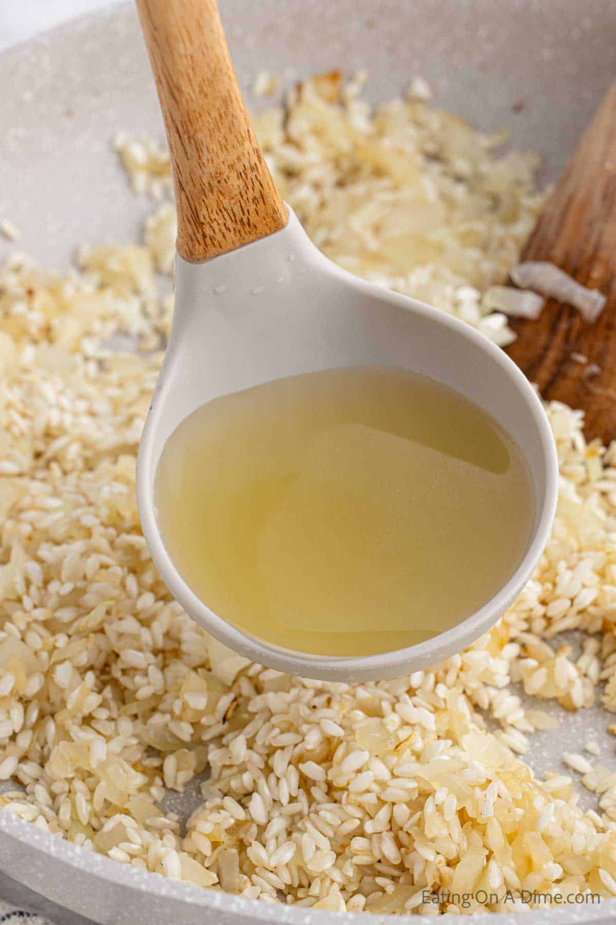 Pouring chicken broth into the risotto