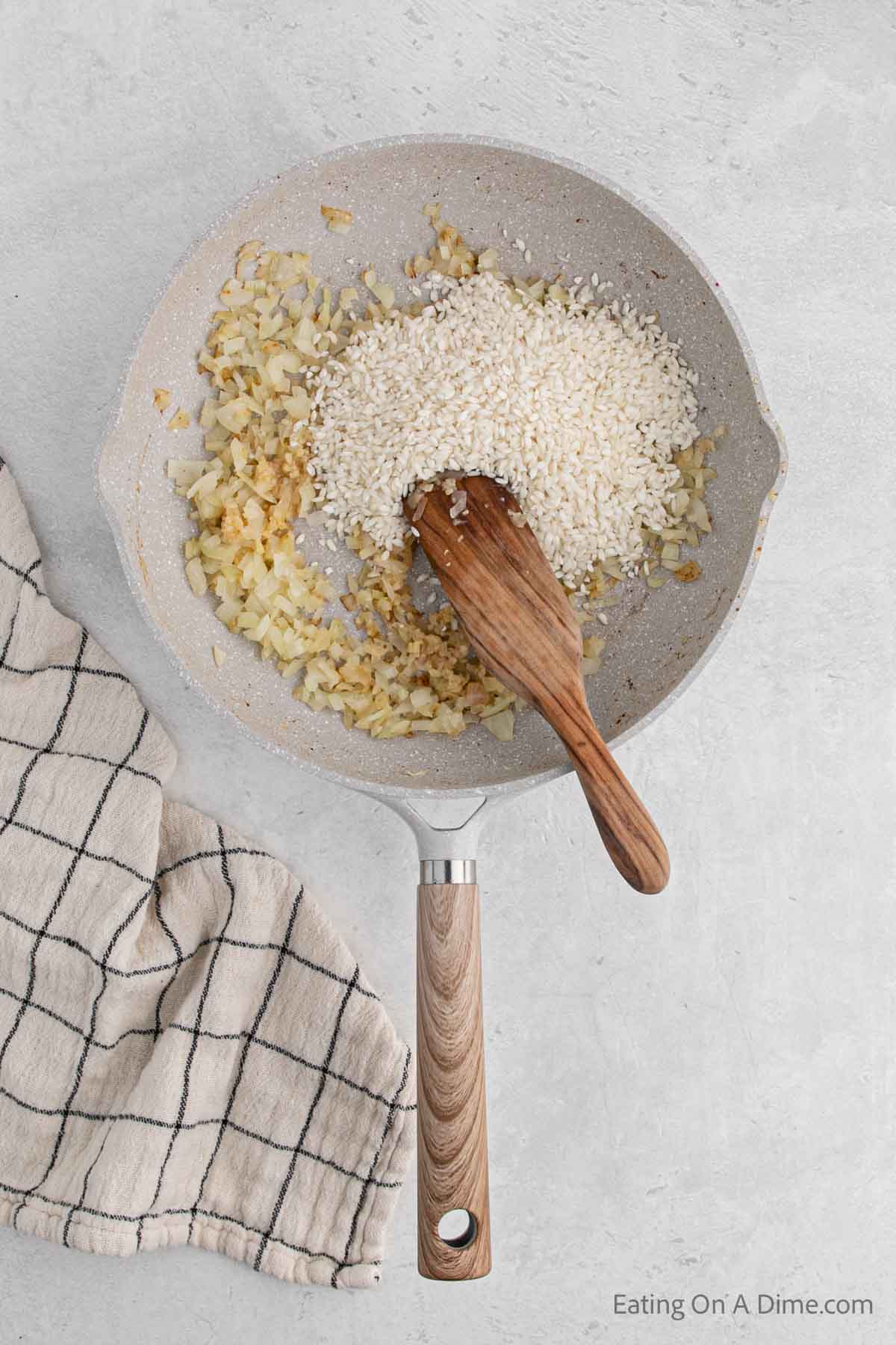 Adding the rice into the skillet with the onions